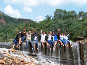 team sitting on a waterfall
